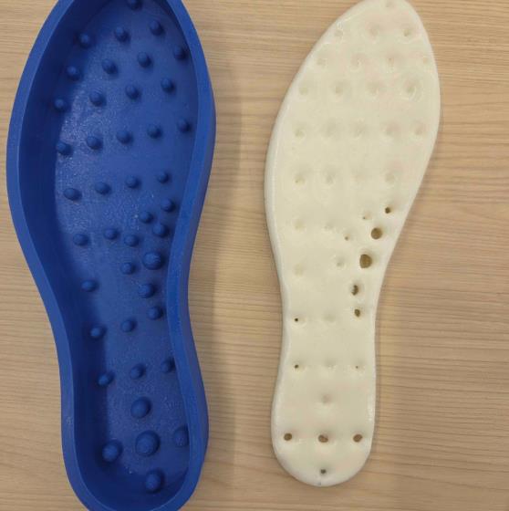 Blue 3D-printed insole mold beside a cast polyurethane foam insole