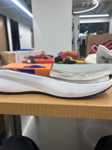 Side cutaway of the shoe showing the embedded mechanical housing and layered midsole